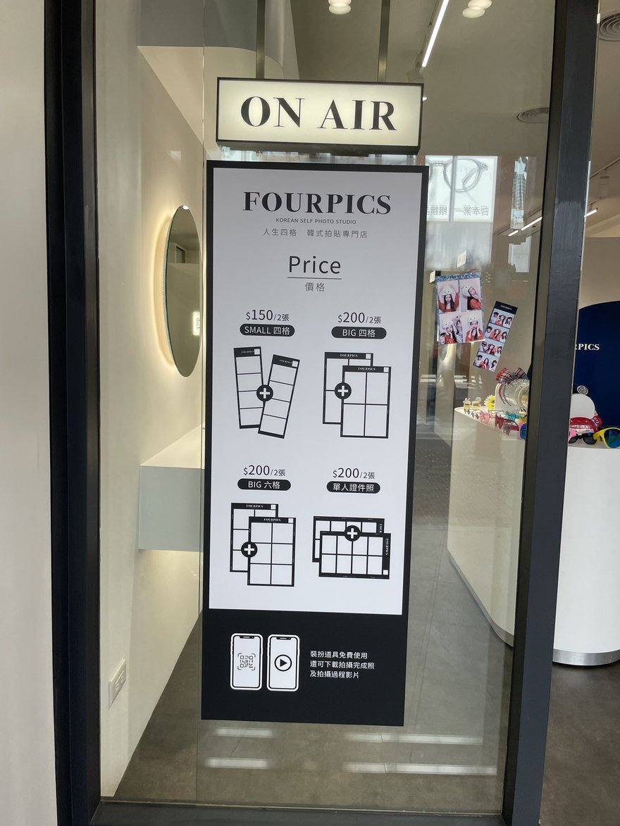 FOURPICS 門口的價目立牌，SMALL 四格 150 元 2 張、BIG 四格 200 元 2 張、BIG 六格 200 元 2 張、單人證件照 200 元 2 張，底部註明裝扮道具免費使用。