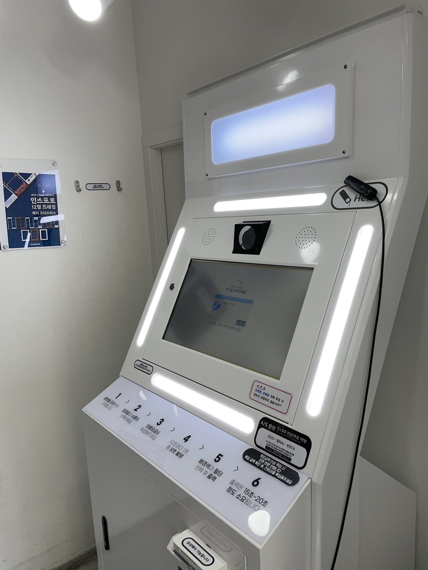 insphoto 的白色直立式機台，上方為柔光燈箱與相機模組，中央為觸控螢幕，側邊設有操作按鍵