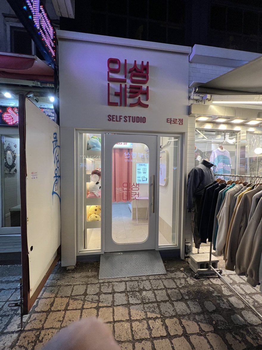 인생네컷的門市入口與燈牌，招牌以霓虹字寫인생네컷