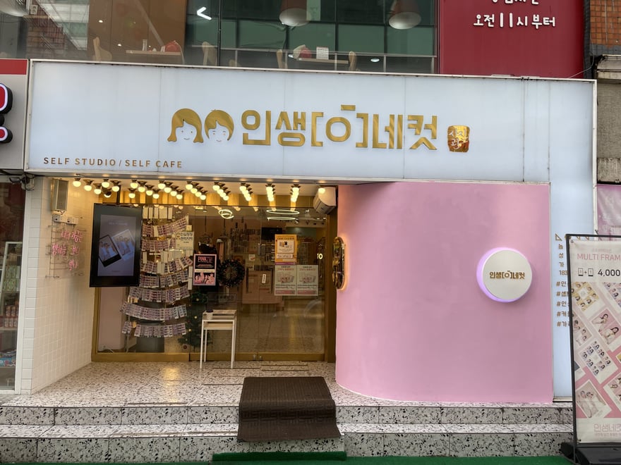 인생네컷的門市外觀，米色與粉色相間的立面，招牌以韓文寫인생네컷並標示 SELF STUDIO