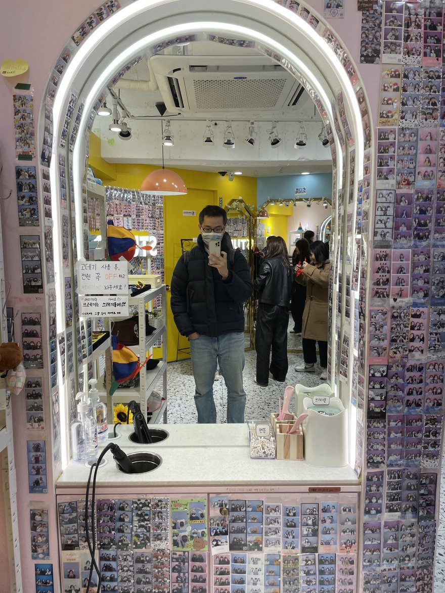 인생네컷店內的拱形鏡面走道，兩側牆面貼滿密集的顧客四格樣張