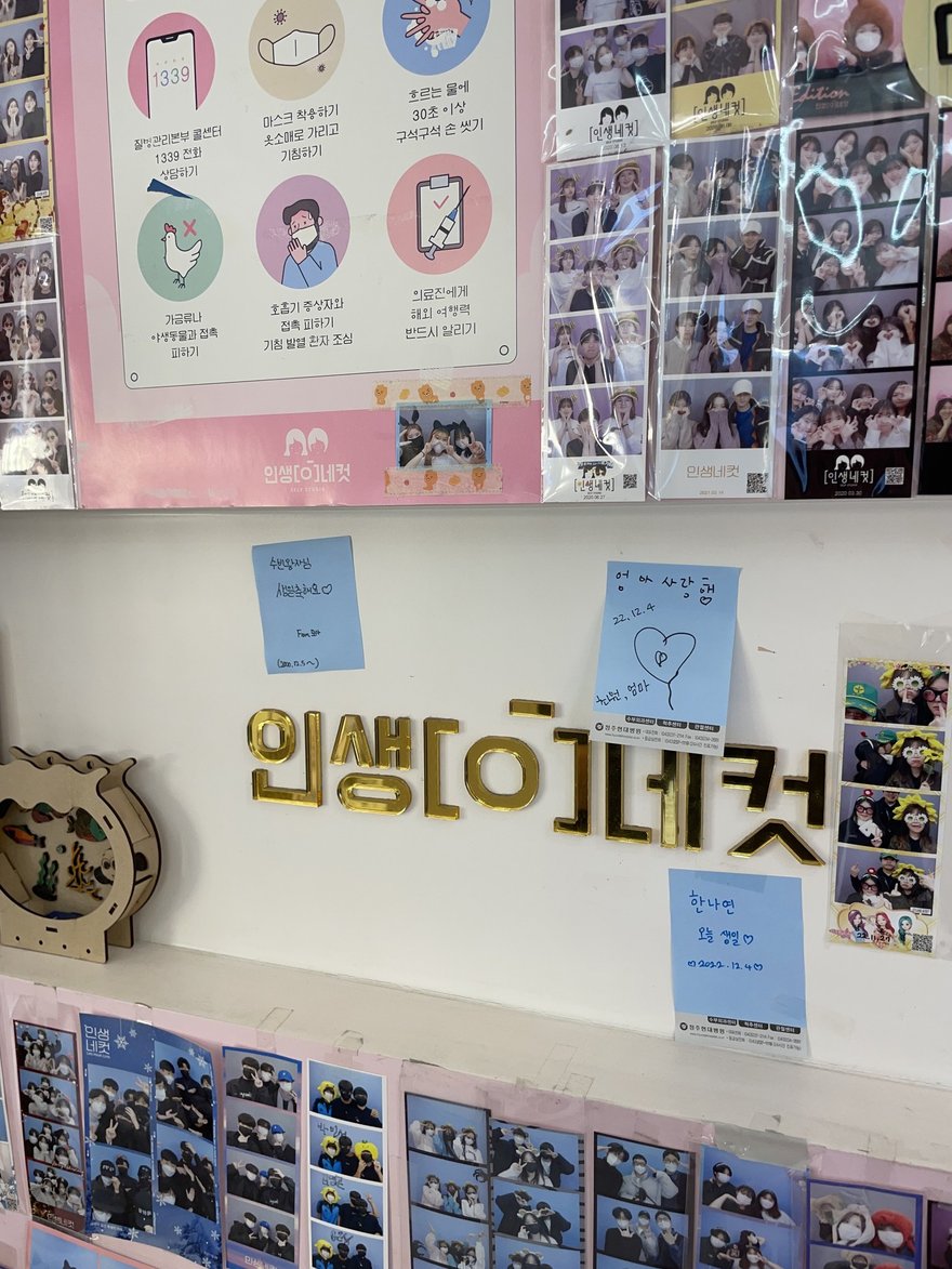 인생네컷店內的品牌標示牆，牆上以韓文寫인생네컷並貼有便條與樣張