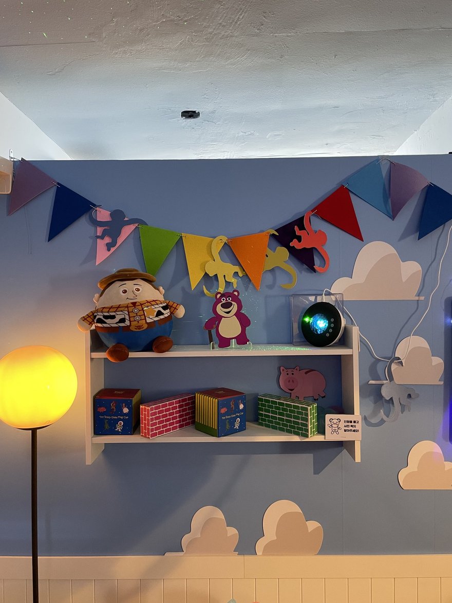 인생네컷複合店內的雲朵佈景與展示層架，藍白色系搭配玩偶陳列
