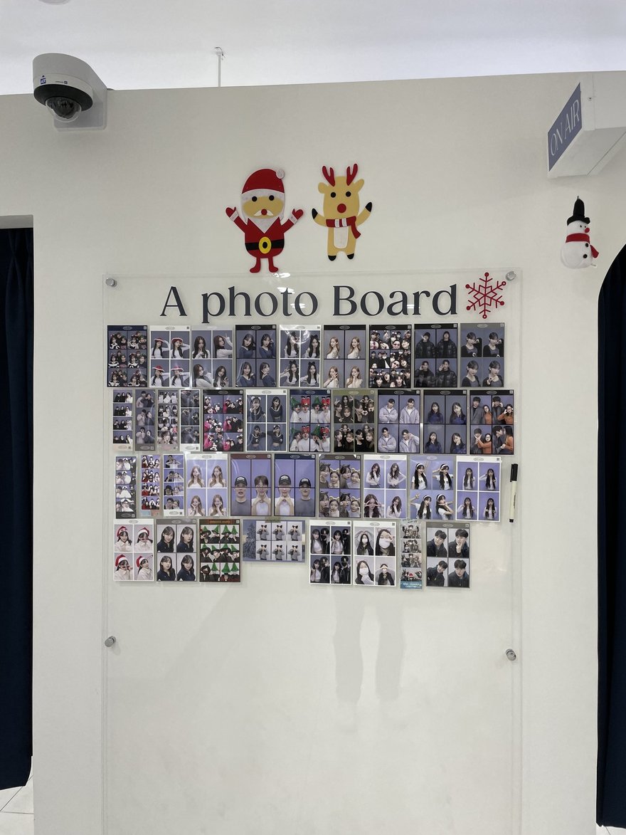 Oldmoon Self Studio 店內的 A photo Board 樣張牆，白色牆面上以聖誕裝飾點綴，中央貼滿顧客的四格照片