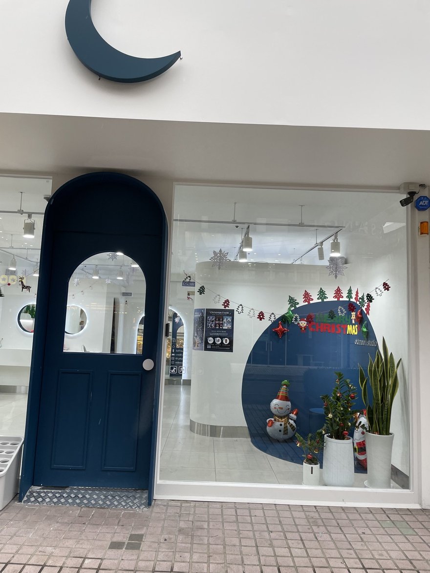 Oldmoon Self Studio 的門市外觀，米白色牆面搭配深藍色拱形門，門楣上方掛著藍色新月造型招牌