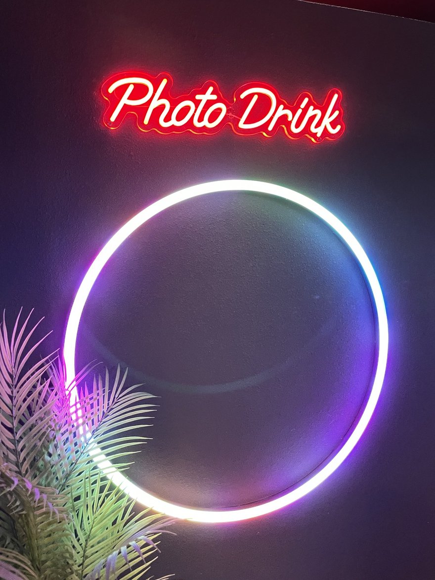 PHOTO DRINK 店內的圓形環燈裝置與 Photo Drink 紅色霓虹字