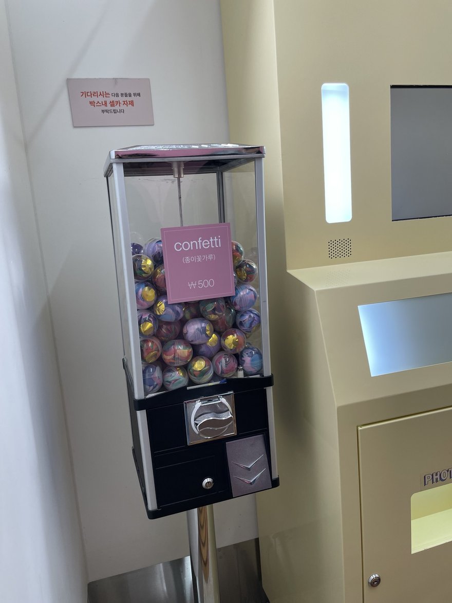 Photo in the Box 店內的扭蛋機與機台，扭蛋機內裝滿彩色扭蛋球