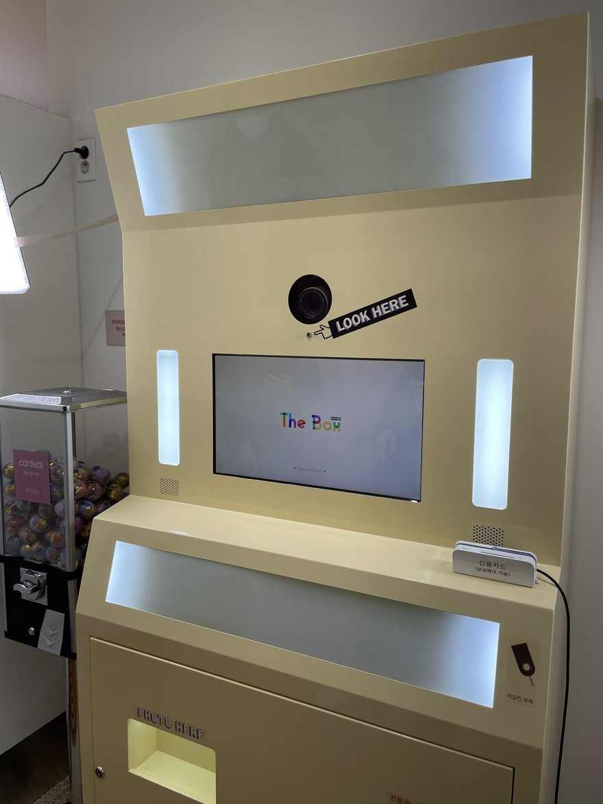Photo in the Box 的白色機台，上方為柔光燈條與相機模組，中央為觸控螢幕