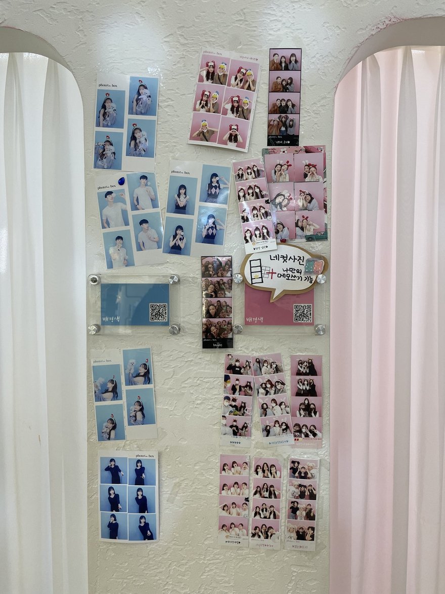 Photo in the Box 的另一面樣張牆，粉色布簾旁貼滿顧客的四格照片