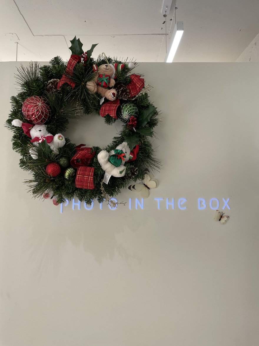 Photo in the Box 商場店牆上的聖誕花圈裝飾，底下以燈條寫出 PHOTO IN THE BOX 字樣