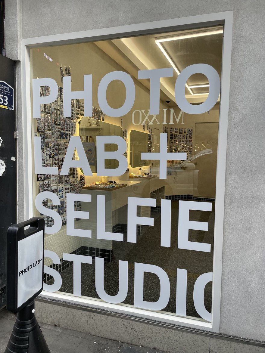 PHOTO LAB+ 玻璃立面的特寫，SELFIE STUDIO 字樣佔滿整片玻璃高度