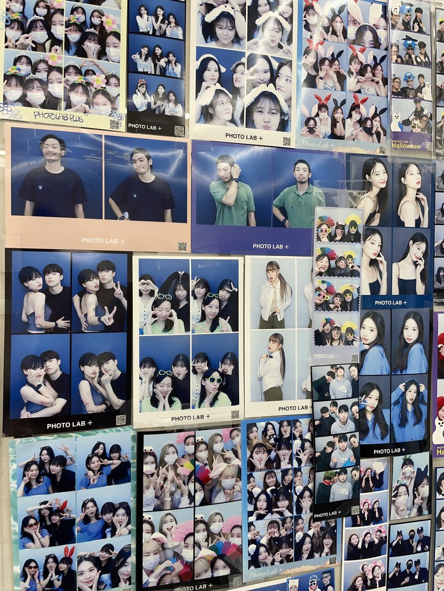 PHOTO LAB+ 店內的樣張牆，藍白黑三色版面的顧客四格照片密集貼滿整面