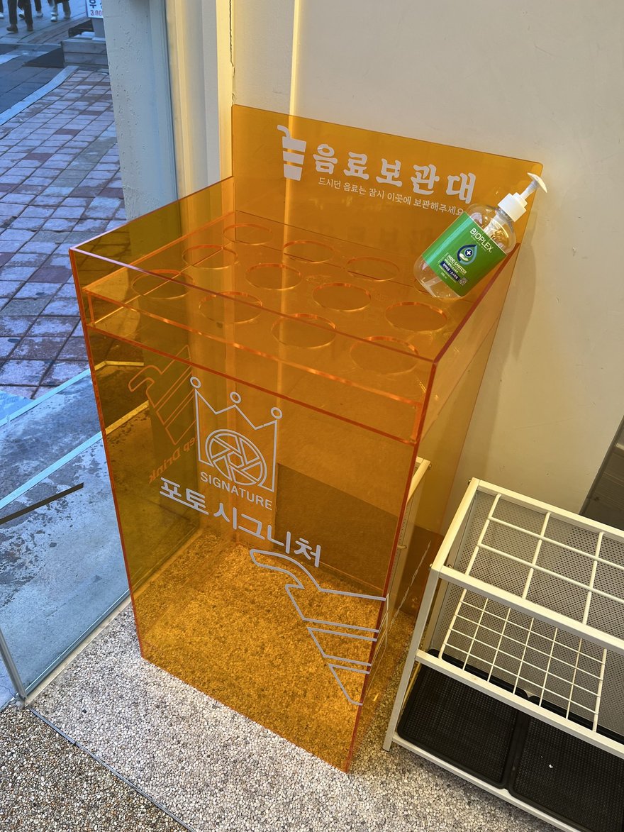 Photo Signature 另一家門市的橘色雨傘保管架，同樣印有品牌名