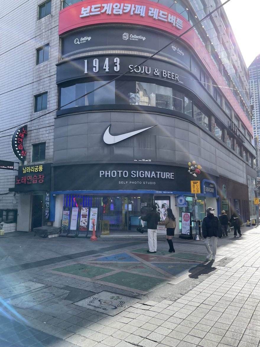 Photo Signature 門市所在的街角建物，一樓為門市、上方為其他店家招牌