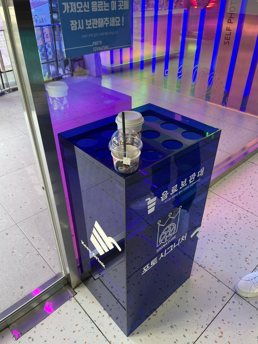 Photo Signature 雨傘保管架的另一個角度，箱體在藍色燈光下反光