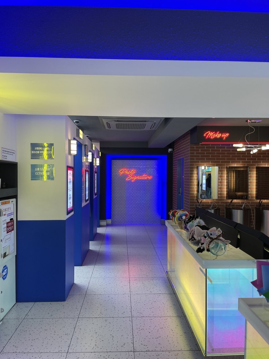 Photo Signature 地下街門市的走道，兩側為藍色 LED 燈牆與商店