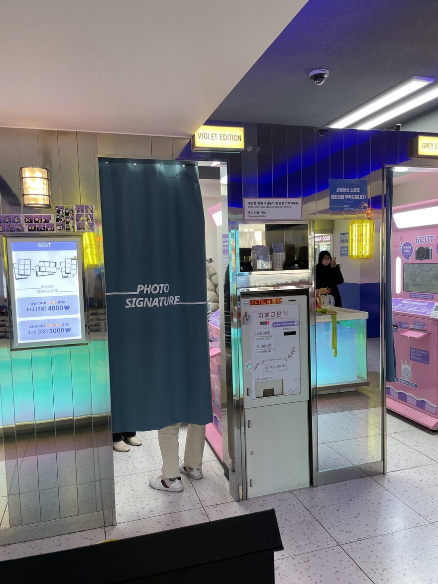Photo Signature 地下街門市的機台與燈牆，顧客在旁等候