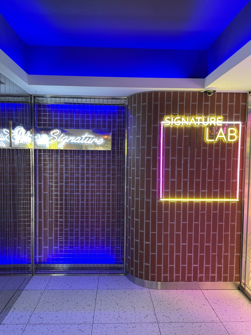 Photo Signature 地下街店的 SIGNATURE LAB 霓虹招牌與磚牆走道