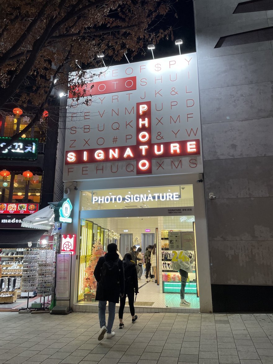Photo Signature 夜間門市的直式招牌與入口燈光