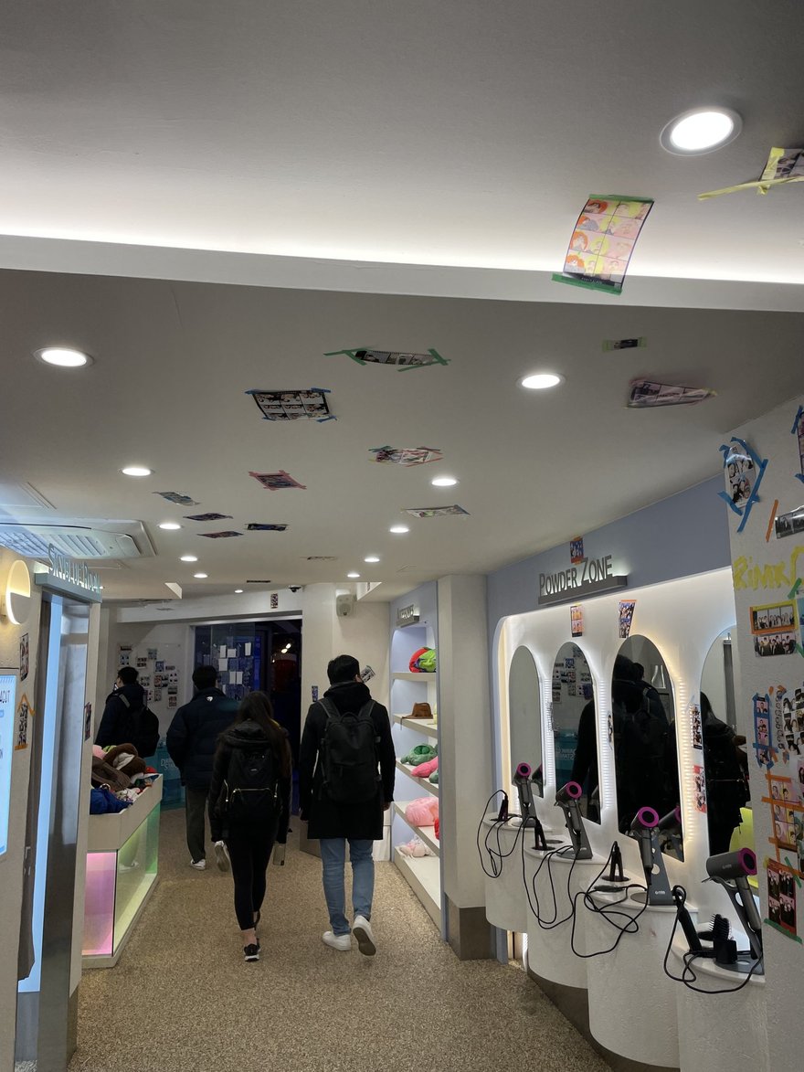 Photo Slate 店內的走道，兩側為拍攝棚與 POWDER ZONE 補妝區標示