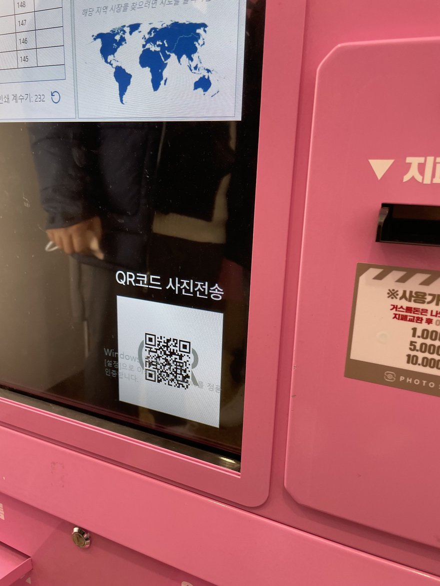 Photo Slate 的 QR 傳圖畫面特寫，粉紅色機台上顯示 QR코드 사진전송字樣與 QR code