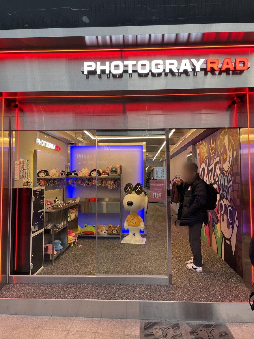 Photogray RAD 第二家門市的外觀，紅色燈框招牌下方為店面入口，上方掛有임대招租牌與 051 開頭電話