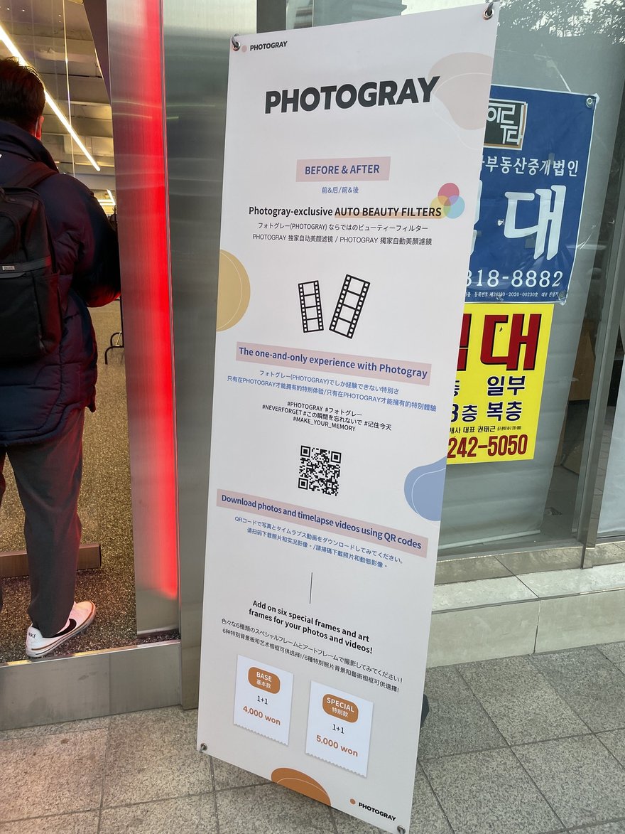 Photogray RAD 門口的另一面 PHOTOGRAY 立牌與店面入口，紅色燈框內可見走道與道具陳列