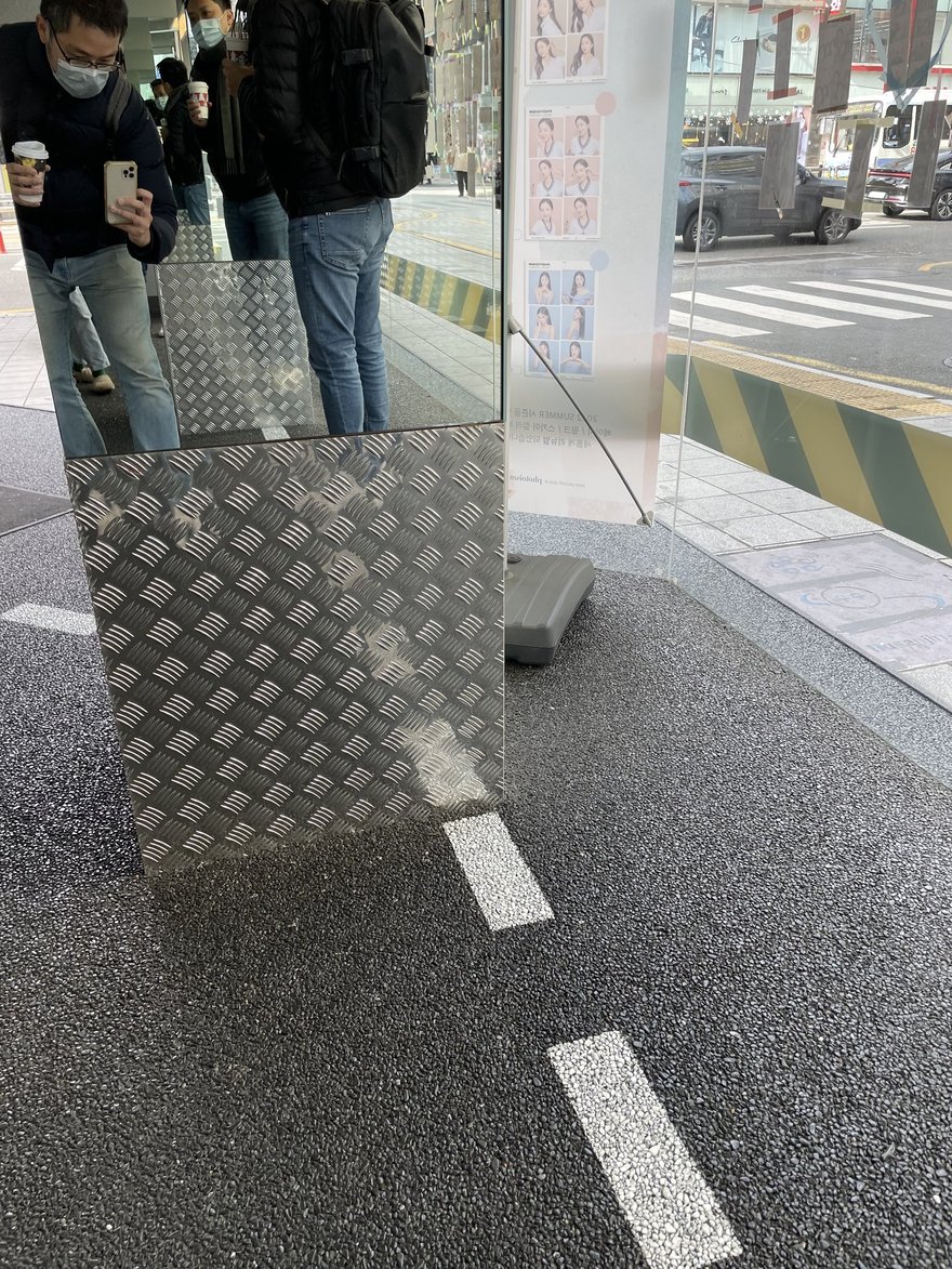 PHOTOISM COLORED 的機台與 LOOK HERE 指示牌，兩側為長條燈管