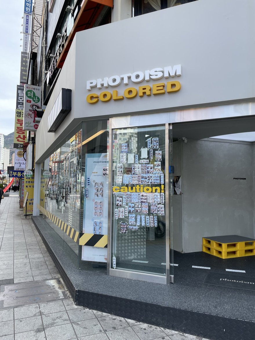 PHOTOISM COLORED 門市外觀的另一個角度，可見黃黑條紋與玻璃門