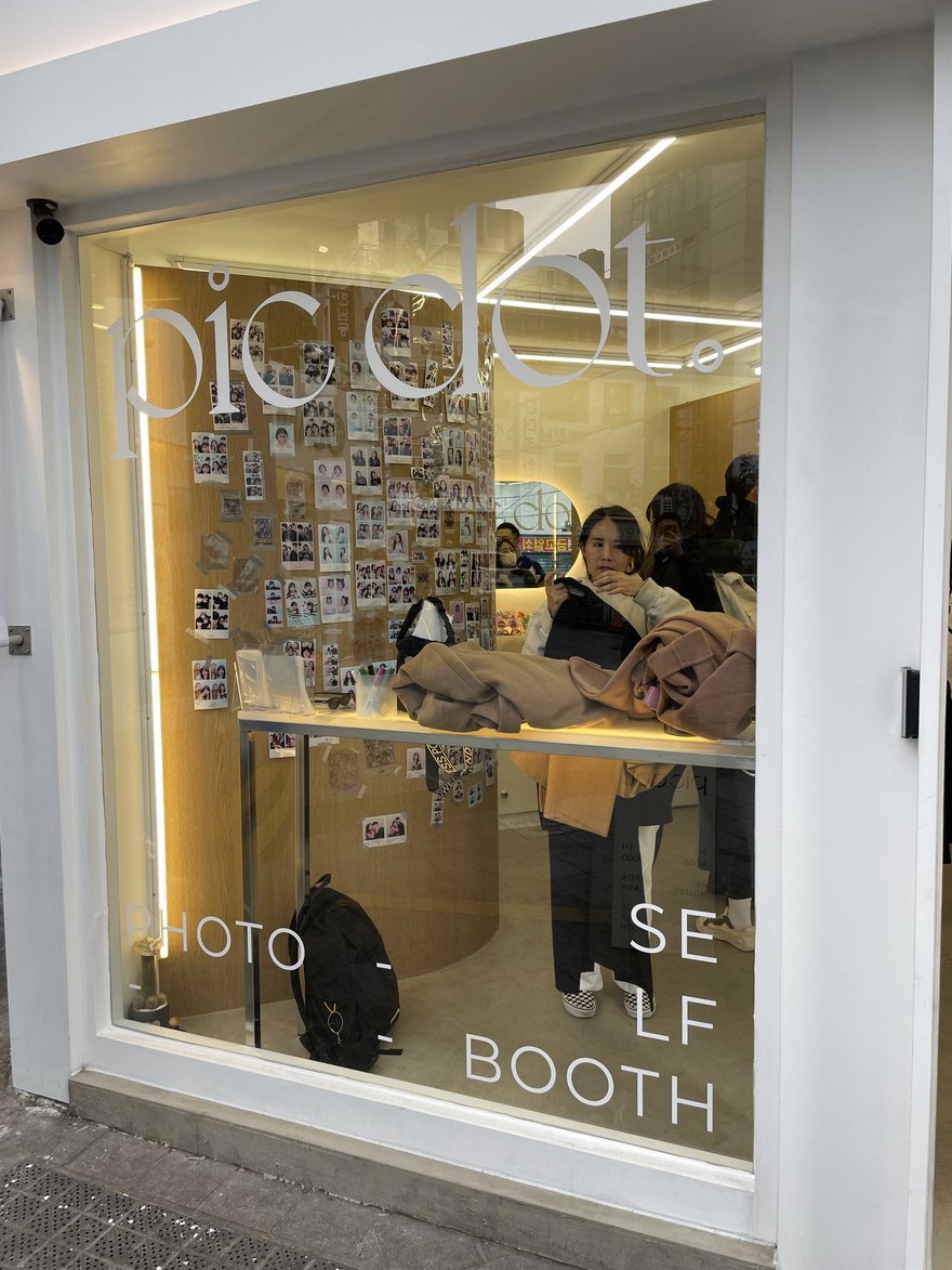 pic dot 店內的樣張牆與展示櫃，牆面貼滿顧客留下的四格照片