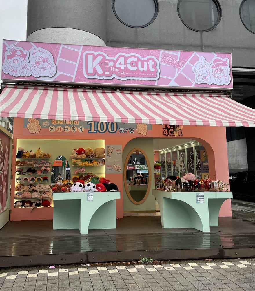 台北東區街邊店的門面，粉紅招牌寫 Kr4Cut 韓風四格，遮陽篷下橫幅寫韓風四格拍貼館試拍推廣價 100 元一次