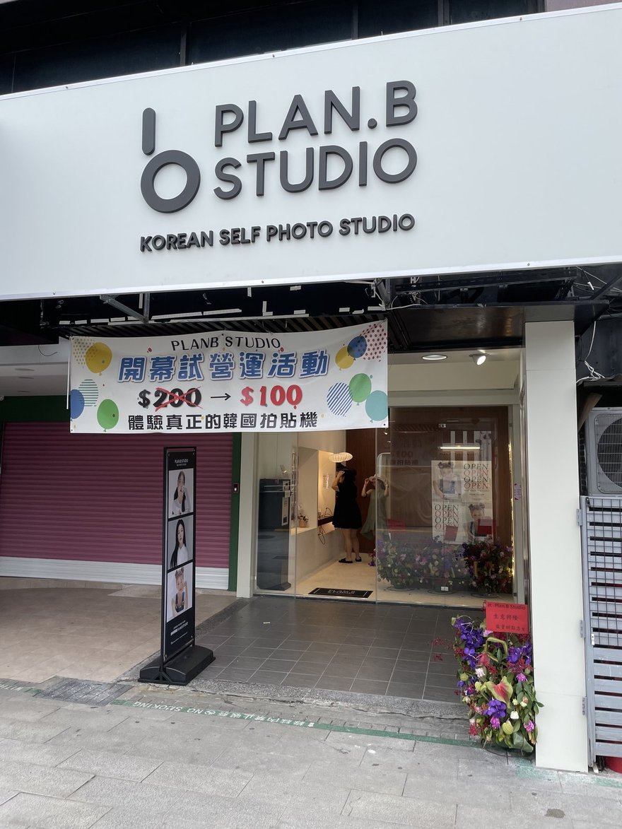 Plan.B Studio 西門店開幕當天的店招與布條，招牌寫 KOREAN SELF PHOTO STUDIO，紅布條寫開幕試營運活動 200 元降為 100 元、體驗真正的韓國拍貼機