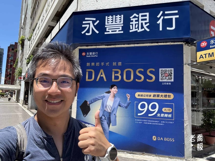 老喬在永豐銀行分行門口自拍，背後是 2025 年 DA BOSS「創業起手式」看板，主打新設公司享創業大禮包、每月 99 次免費轉帳