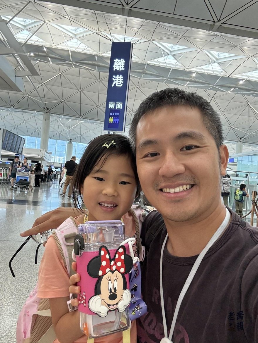 老喬與哈哈在香港國際機場的離港指標牌前自拍