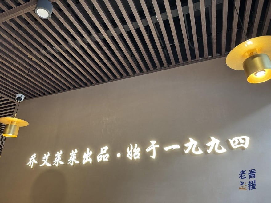 萊萊小籠店內天花板下方的牆面，金色字體寫著喬艾萊萊出品·始于一九九四