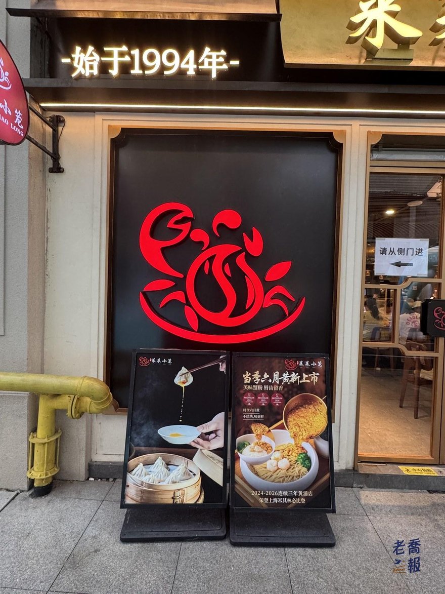 萊萊小籠店外的黑色立牌，上方寫著始于 1994 年，中間是紅色的螃蟹造型商標，下方立著兩塊菜色宣傳板