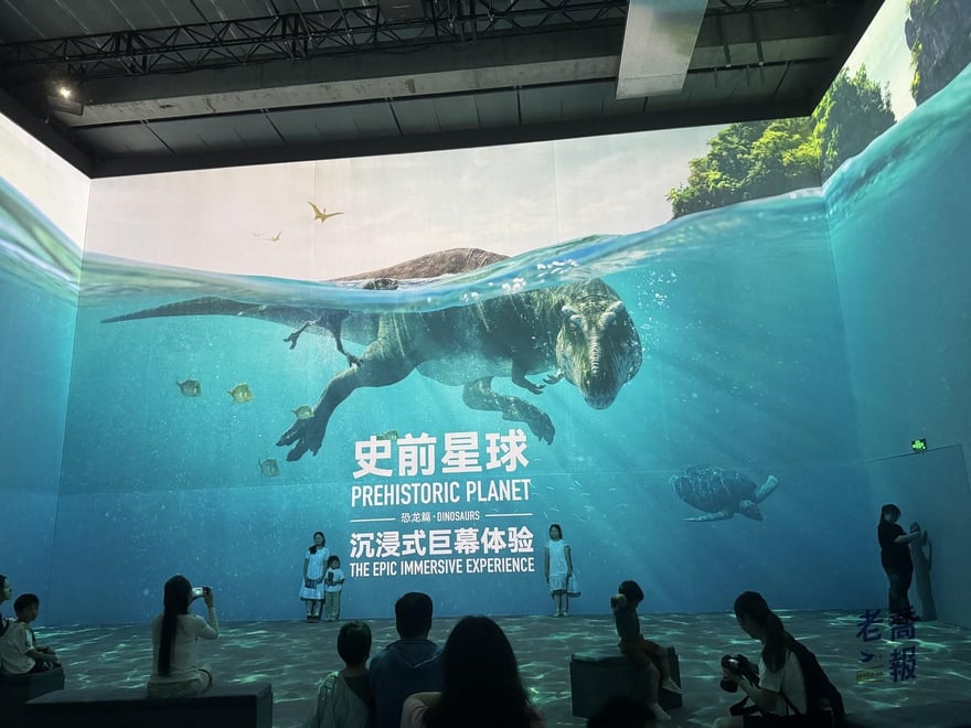 展場入口牆面的史前星球主視覺，寫著沉浸式巨幕體驗與 Prehistoric Planet 字樣