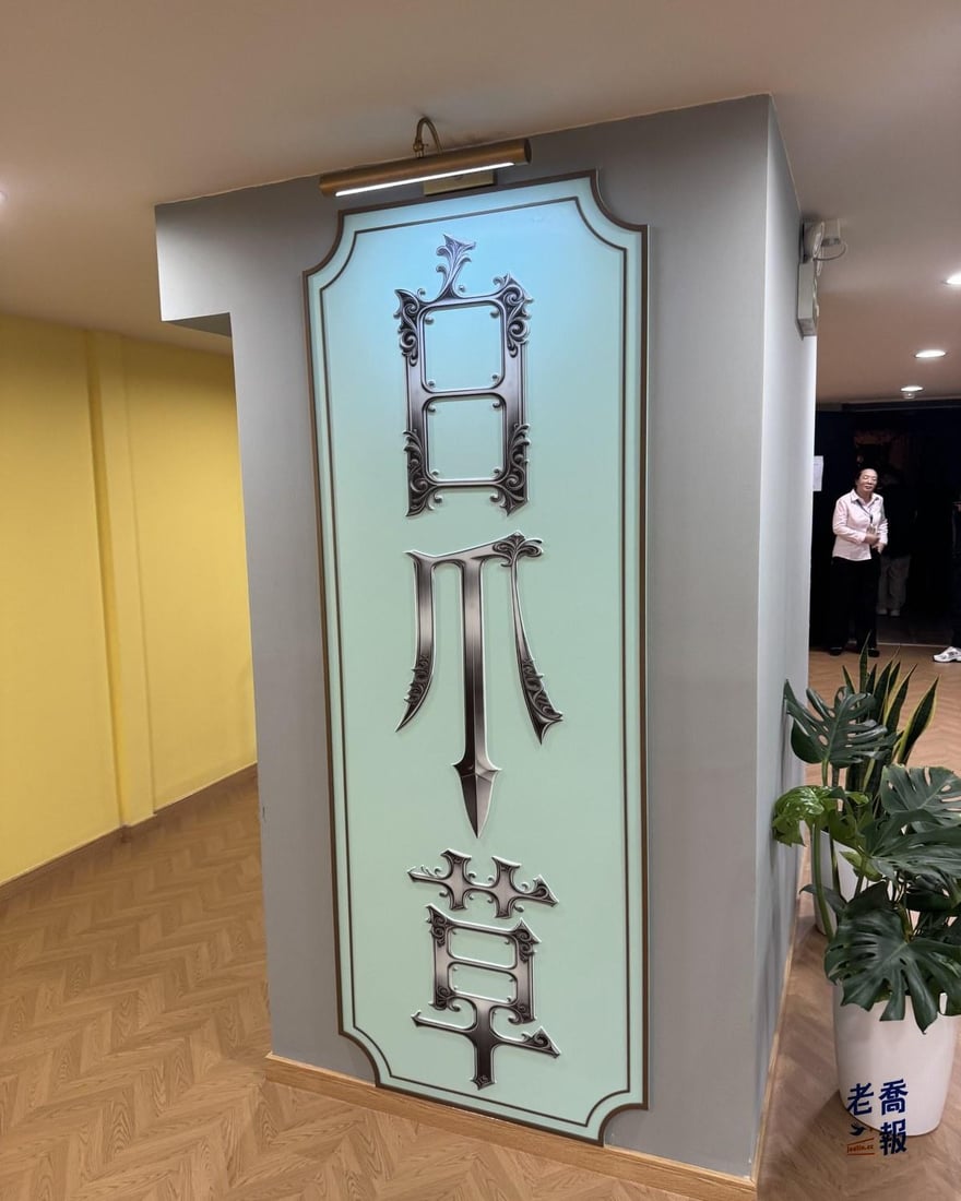 和平影都六樓映·ING劇場入口的白爪草燈箱，白底藍框、劇名以花體字直排，旁邊擺著綠色盆栽