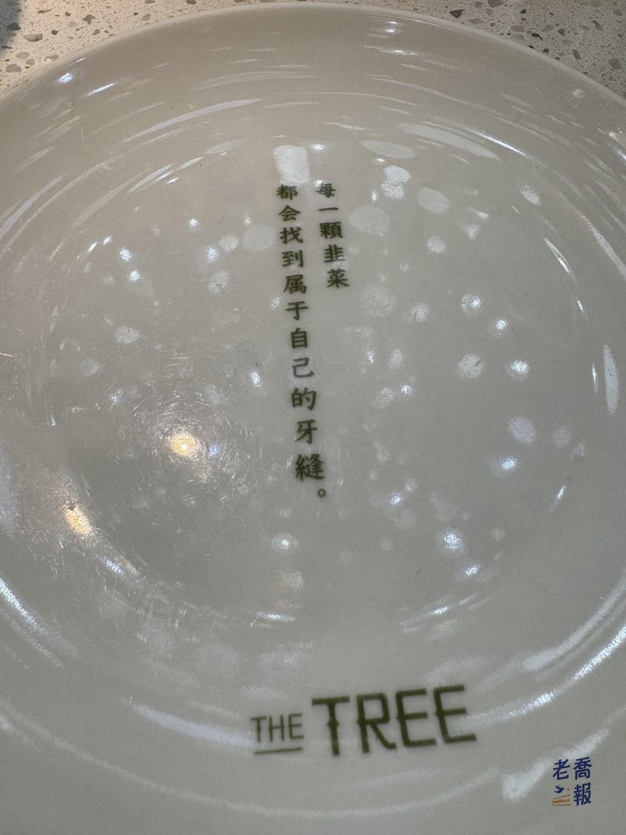 大樹餐廳的餐盤底部，印著「每一顆韭菜都會找到屬於自己的牙縫」與 THE TREE 標誌