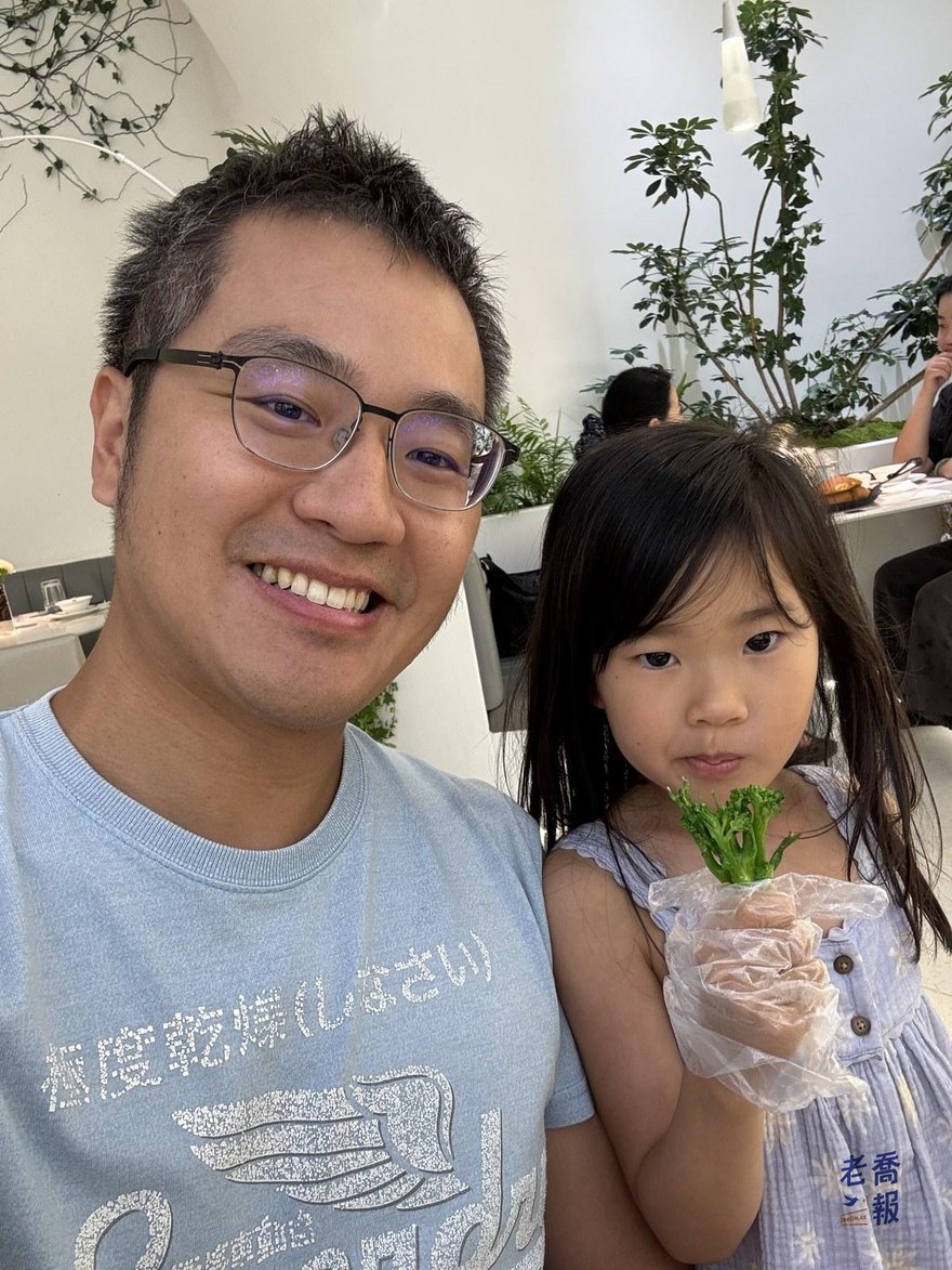 老喬與哈哈的合照，哈哈手上戴著塑膠手套拿著青菜，背景是店內大片綠植