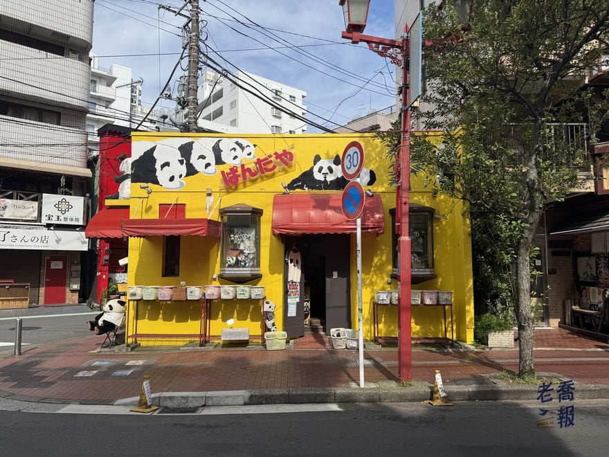 橫濱中華街整棟漆成黃色的熊貓雜貨專門店ぱんだや，門口坐著一隻熊貓玩偶