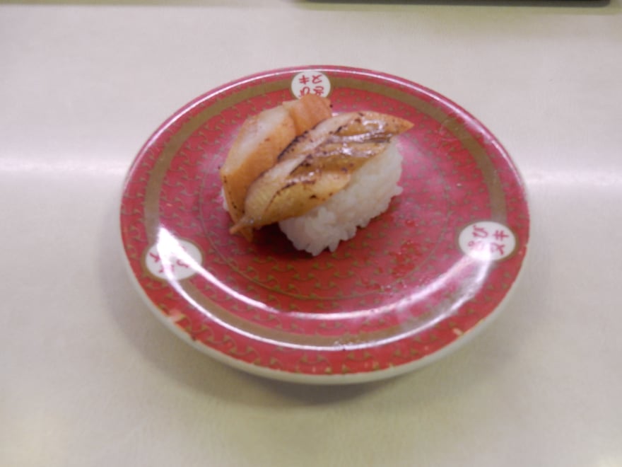 日本迴轉壽司店餐盤上的炙燒穴子握壽司