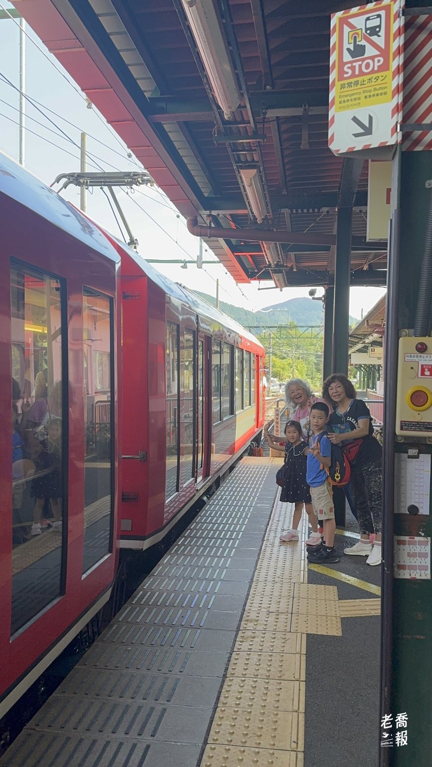 兩位奶奶帶著孩子們在強羅月台準備上車，紅色的登山電車就停在旁邊