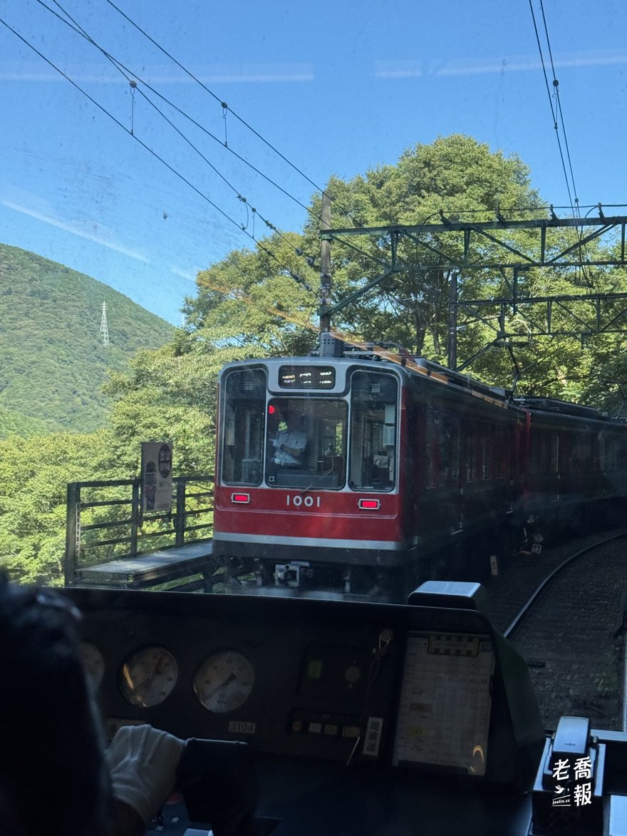 透過駕駛室玻璃看對向的紅色列車駛近：登山電車大部分是單線，上下行要在車站交會錯車