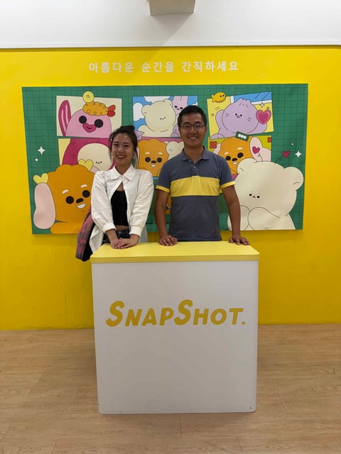 中央社採訪時，老喬站在 Snapshot妞拍貼櫃台前合影