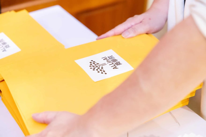 Bright yellow envelopes with 老喬報® logo, used for mailing or packaging, emphasizing branding and professional presentation.