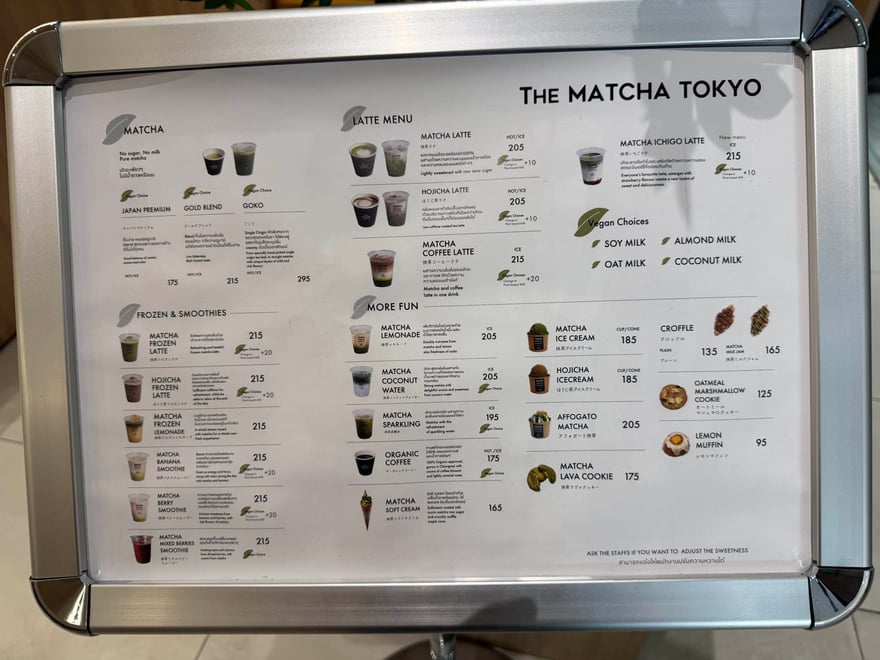 The Matcha Tokyo 的飲品菜單看板，分為抹茶、拿鐵、冰沙與點心等區，標出各品項泰銖價格
