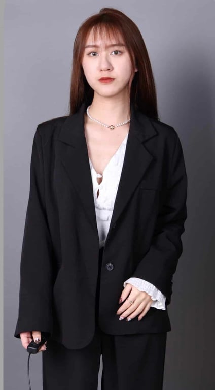 形象照穿搭示範：女生穿黑色西裝外套、站姿，灰色背景