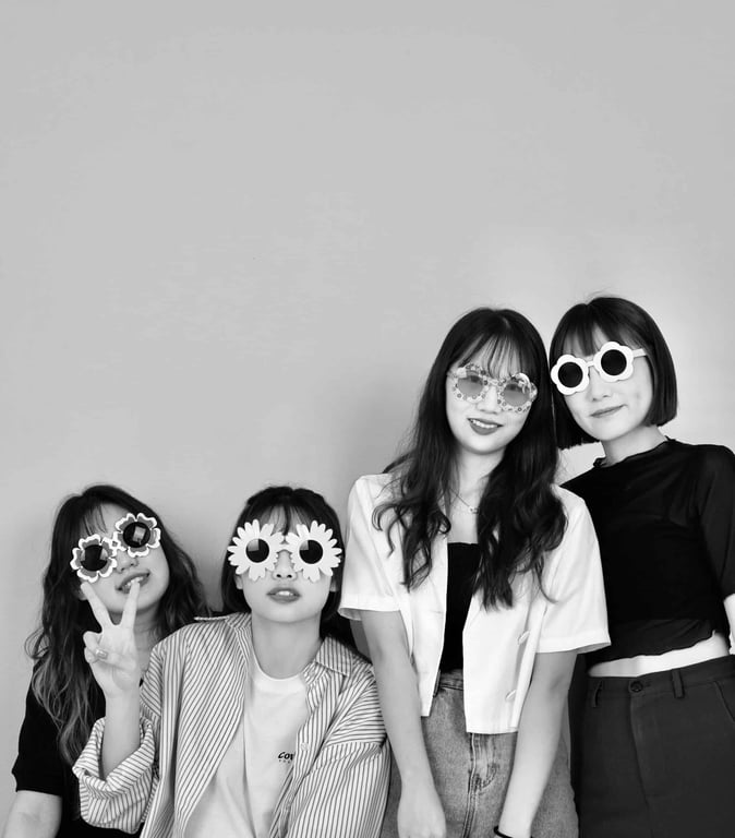 4 人姿勢「一排戴道具」：四位女生站一排，其中幾位戴花朵造型眼鏡，黑白